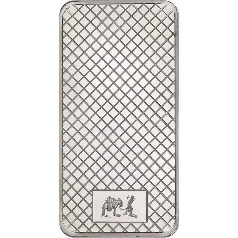 Back view of a silver bullion bar with a crisscross diamond pattern background and a small rectangular engraving at the bottom depicting a prospector with a mule.